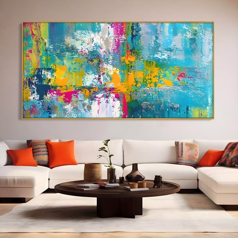 Tablou canvas cu pictura abstracta cu pete albastre si galbene, in rama de aluminiu auriu, pe perete intr-un living